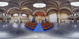 Panoramablick auf einen Kircheninnenraum mit Sitzgelegenheiten.