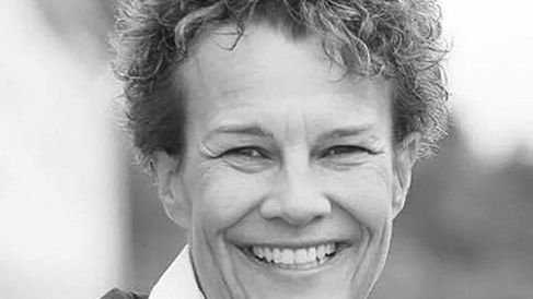 Schwarz-Weiß-Nahaufnahme des lächelnden Gesichts einer Frau.