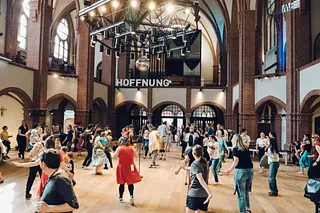 Kirchenfassade neben einem modernen Gebäude.