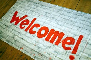 Welcome mat with red text.