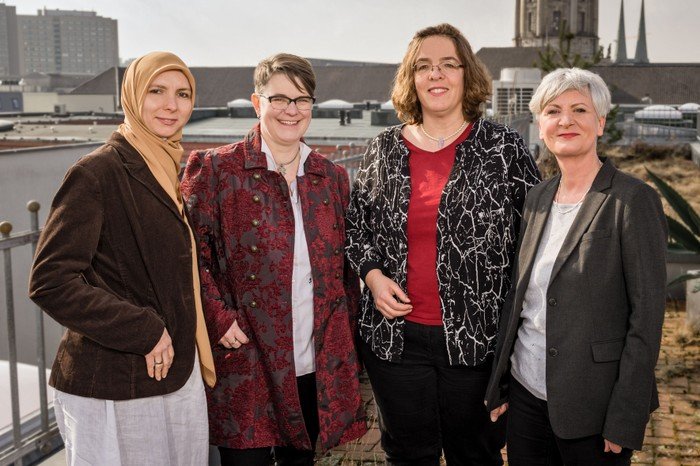 Gruppe von fünf Frauen posiert im Freien.