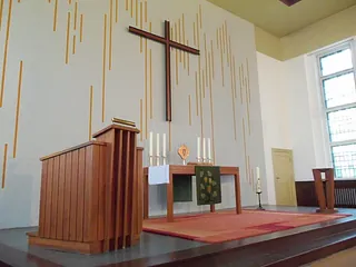 Moderner Kirchenaltar mit einem großen Kreuz.